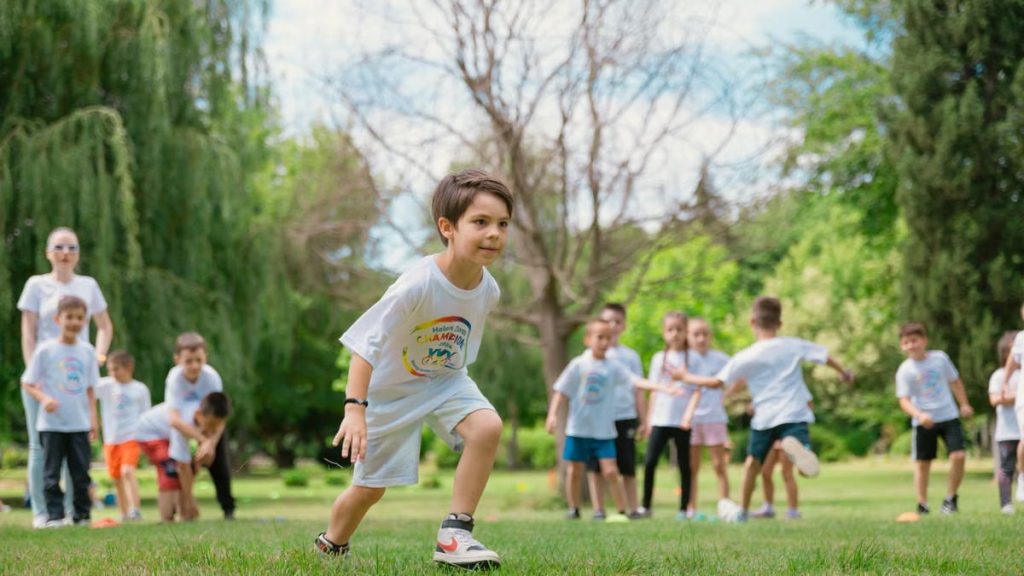 Group of children enjoying outdoor playtime in a green park during summer.