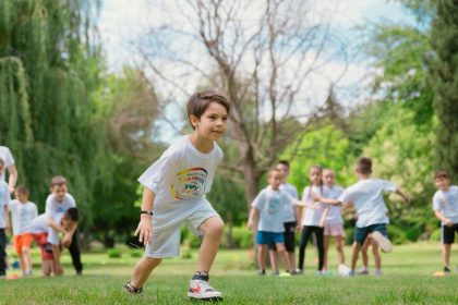 Group of children enjoying outdoor playtime in a green park during summer.