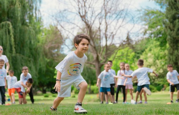 Group of children enjoying outdoor playtime in a green park during summer.